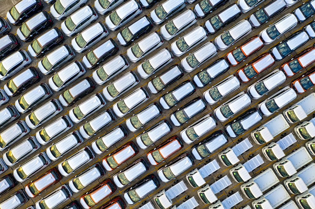 Aerial shot of neatly parked cars in a Jakarta industrial parking lot, showcasing symmetry and pattern.