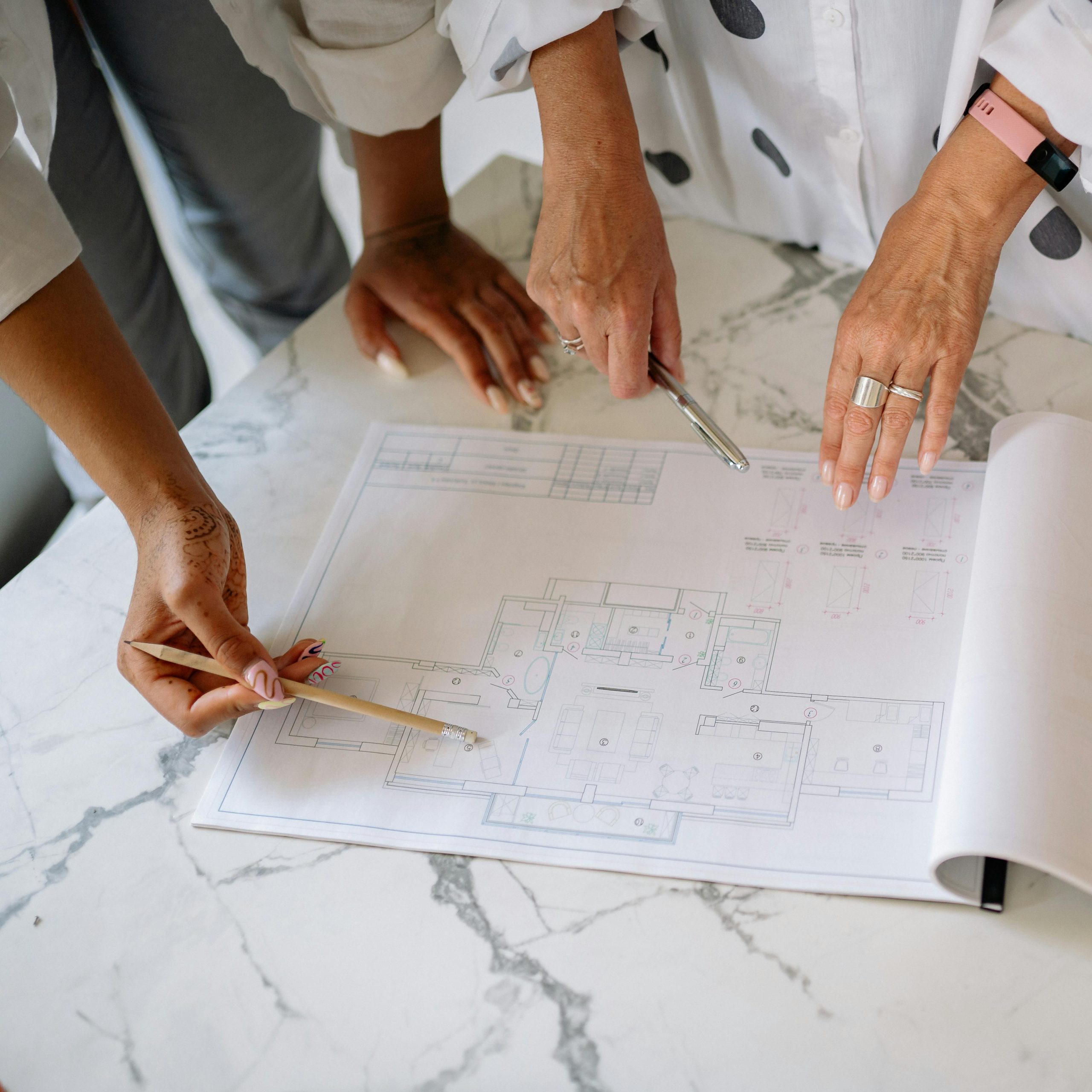 Women collaborating on architectural plans, emphasizing teamwork and precision.